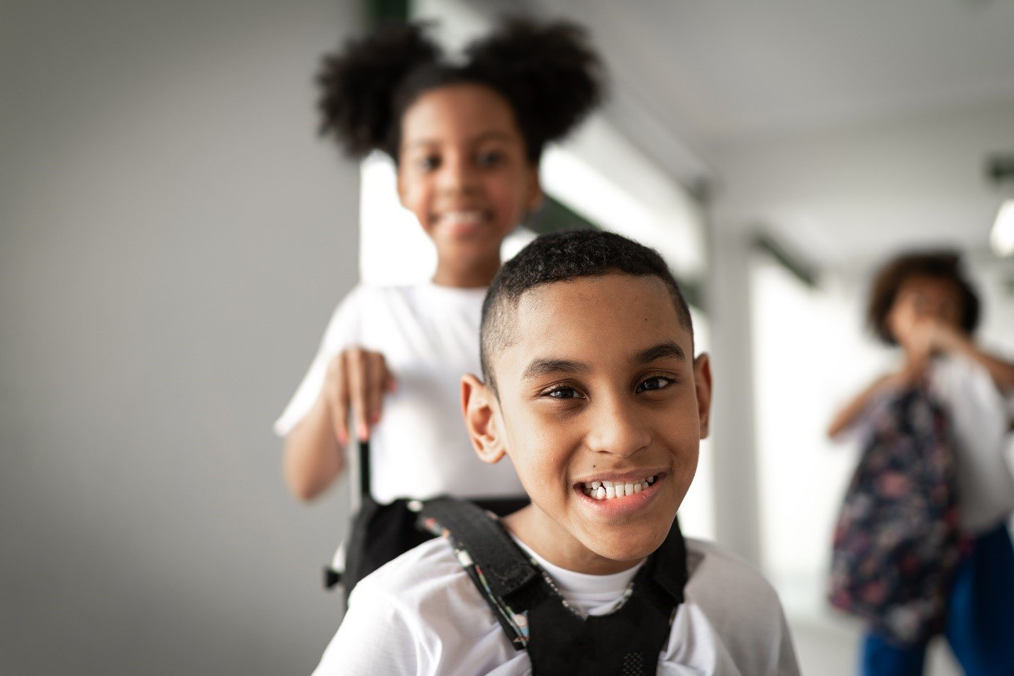 Child with disability smiling alongside siblings